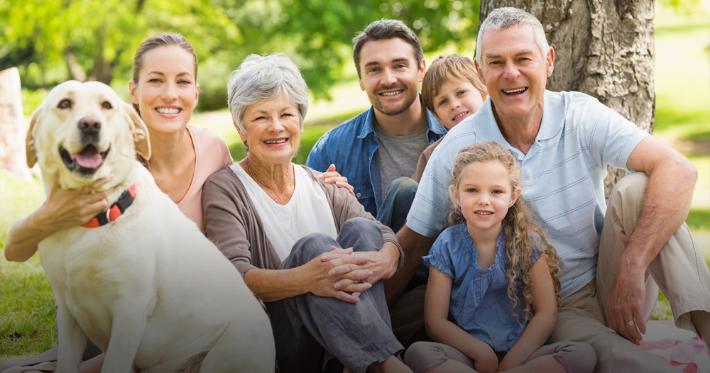 Multi-generational family outdoors with dog